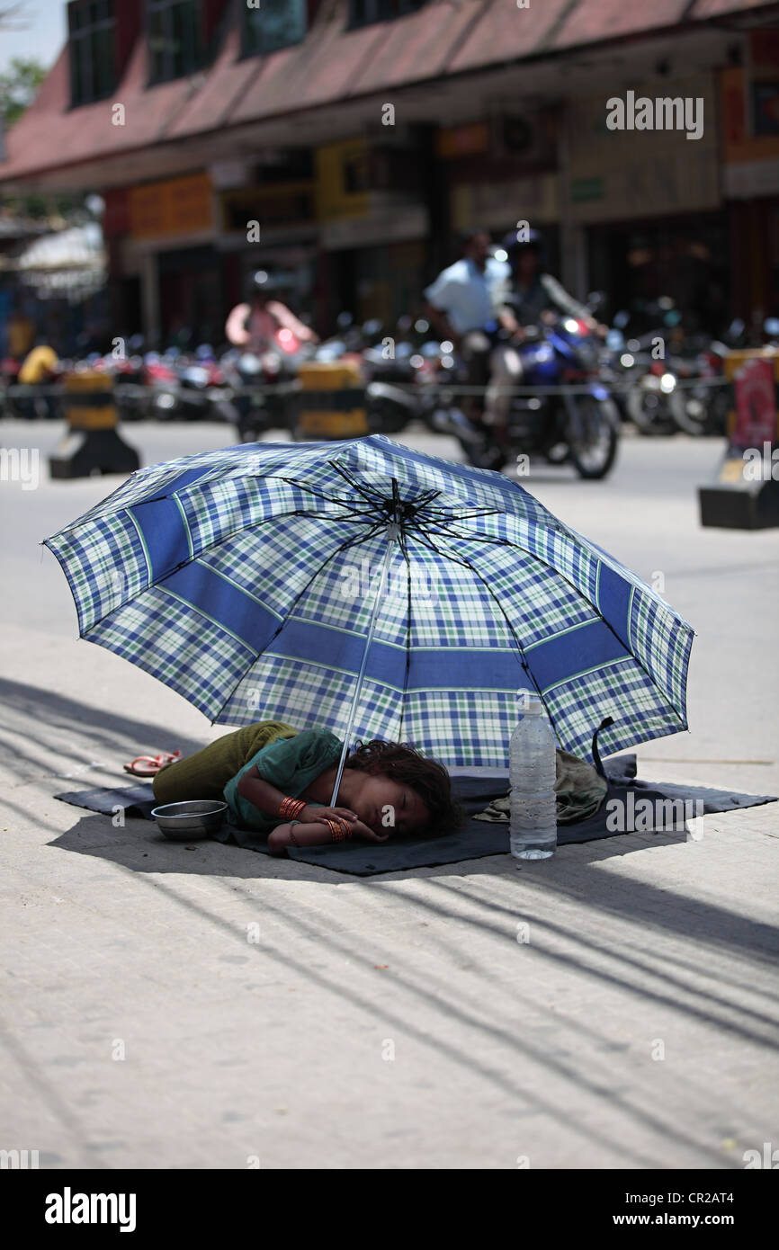 Obdachlose Mädchen schläft unter einem Regenschirm Kathmandu-Nepal Stockfoto