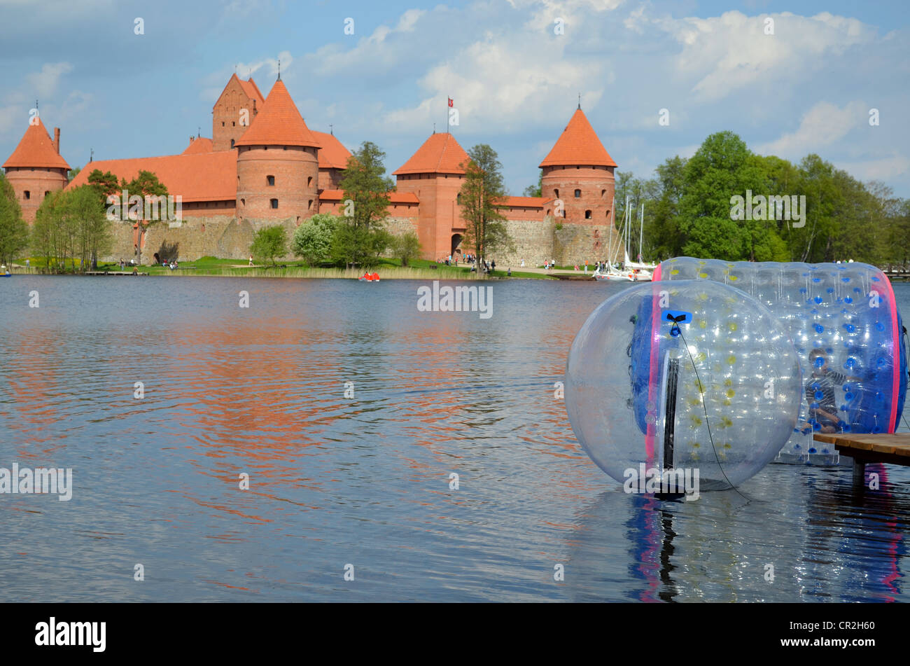 Zorbing Luftblasen auf dem Wasser. Trakai Burg, umgeben von See Galve. XIV - XV Jahrhundert Architektur in Litauen. Stockfoto