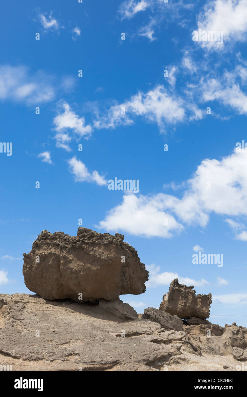 Felsbrocken auf kahlen Felsen und blauer Himmel mit Wolken am Castlepoint, Wairarapa Küste, Wellington, Neuseeland, Ozeanien Stockfoto