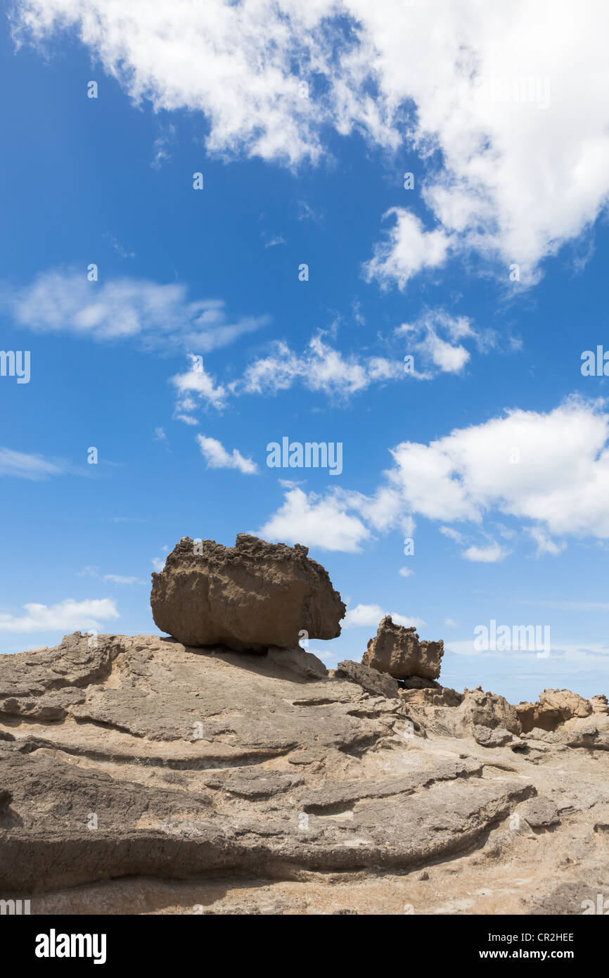 Felsbrocken auf kahlen Felsen und blauer Himmel mit Wolken am Castlepoint, Wairarapa Küste, Wellington, Neuseeland, Ozeanien Stockfoto