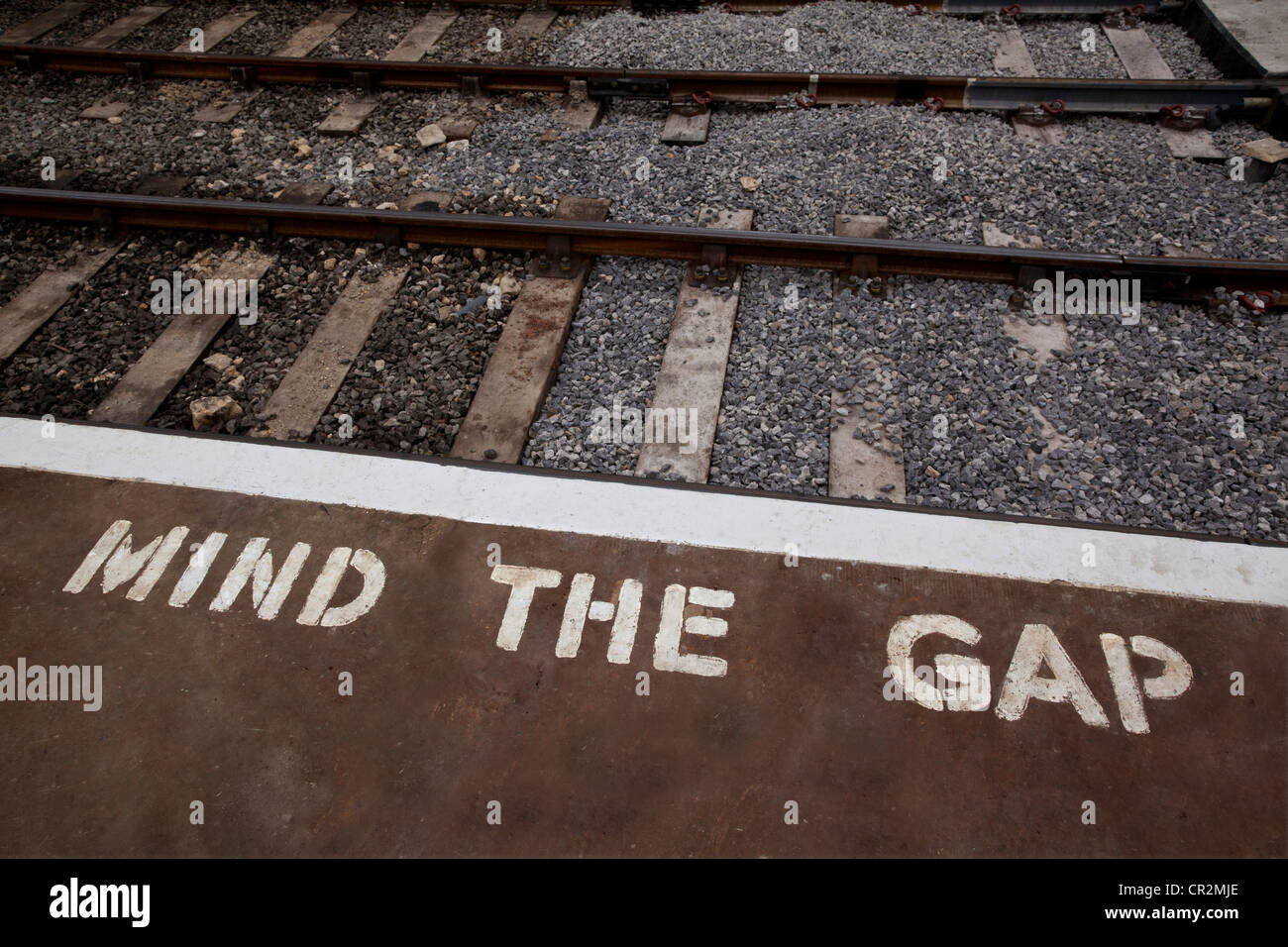 Rand der Bahn Bahnsteig mit bemalten Warnschild Stockfoto