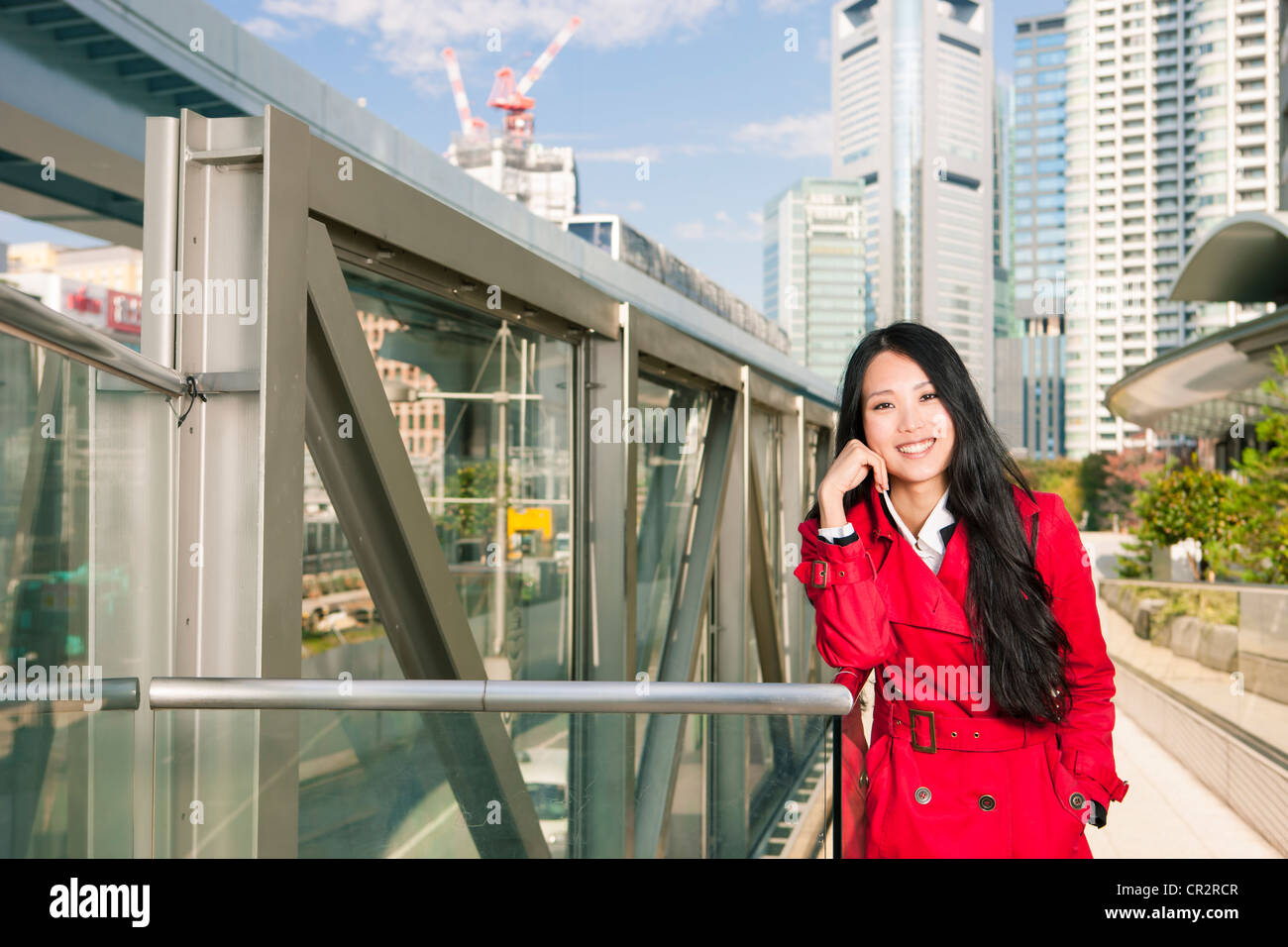 Japanische Frau lehnt sich auf der Schiene in der Innenstadt von Tokio Stockfoto