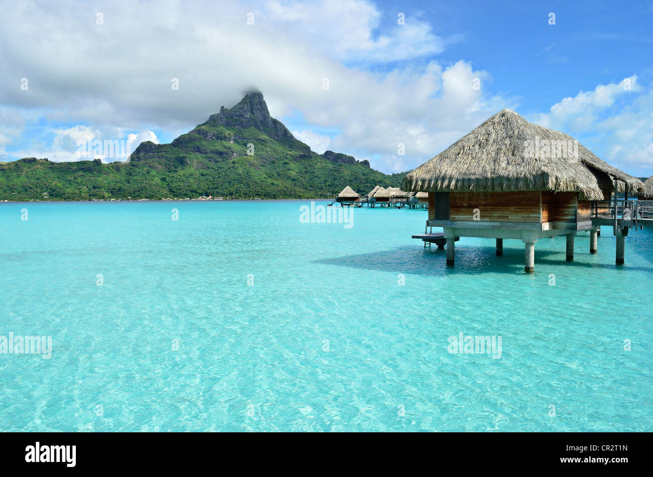 Luxus-Overwater-Bungalow in einem Urlaubsort in der blauen Lagune mit Blick auf die tropische Insel Bora Bora. Stockfoto