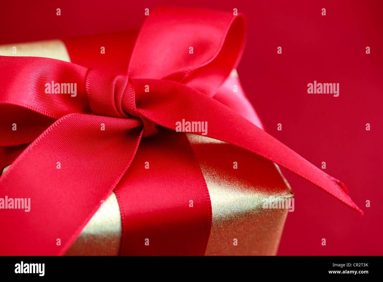 Gold Geschenk-Box mit roter Schleife Stockfoto