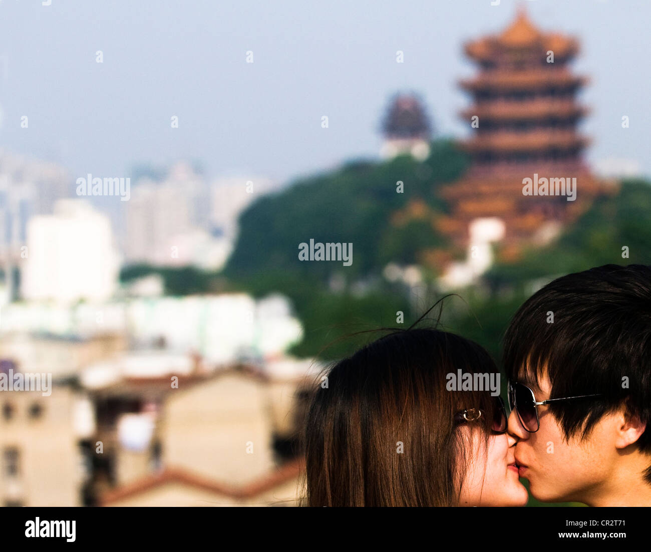 Ein chinesisches Ehepaar küssen mit Blick auf gelbem Kranich-Turm und Wuchang in Wuhan. Stockfoto