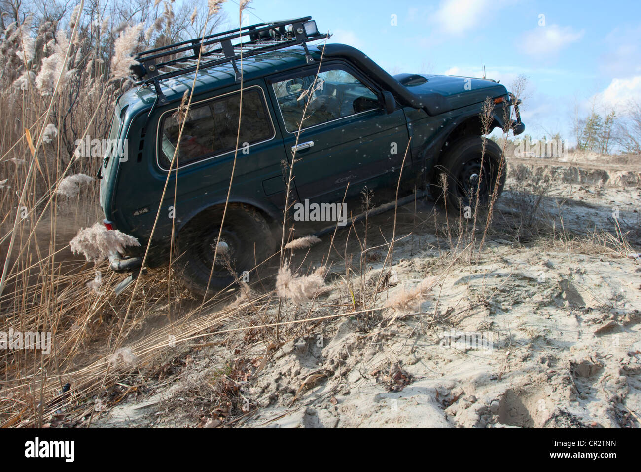 Lada Niva Jeep auf einem Sandweg. Überwindung von einem sandigen Hügel. Stockfoto