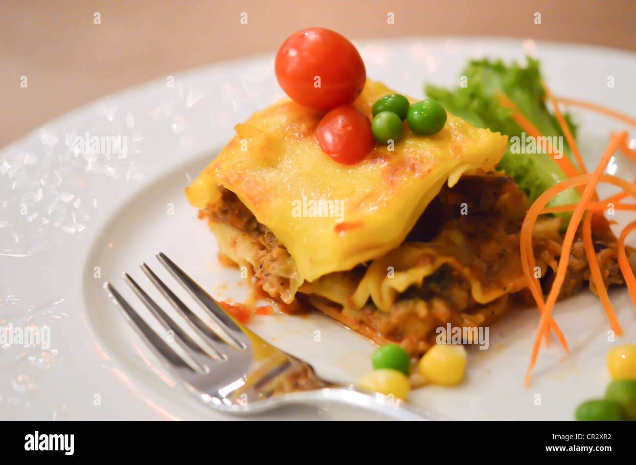 Rindfleisch-Lasagne, serviert mit Tomaten und frischem Gemüse Stockfoto