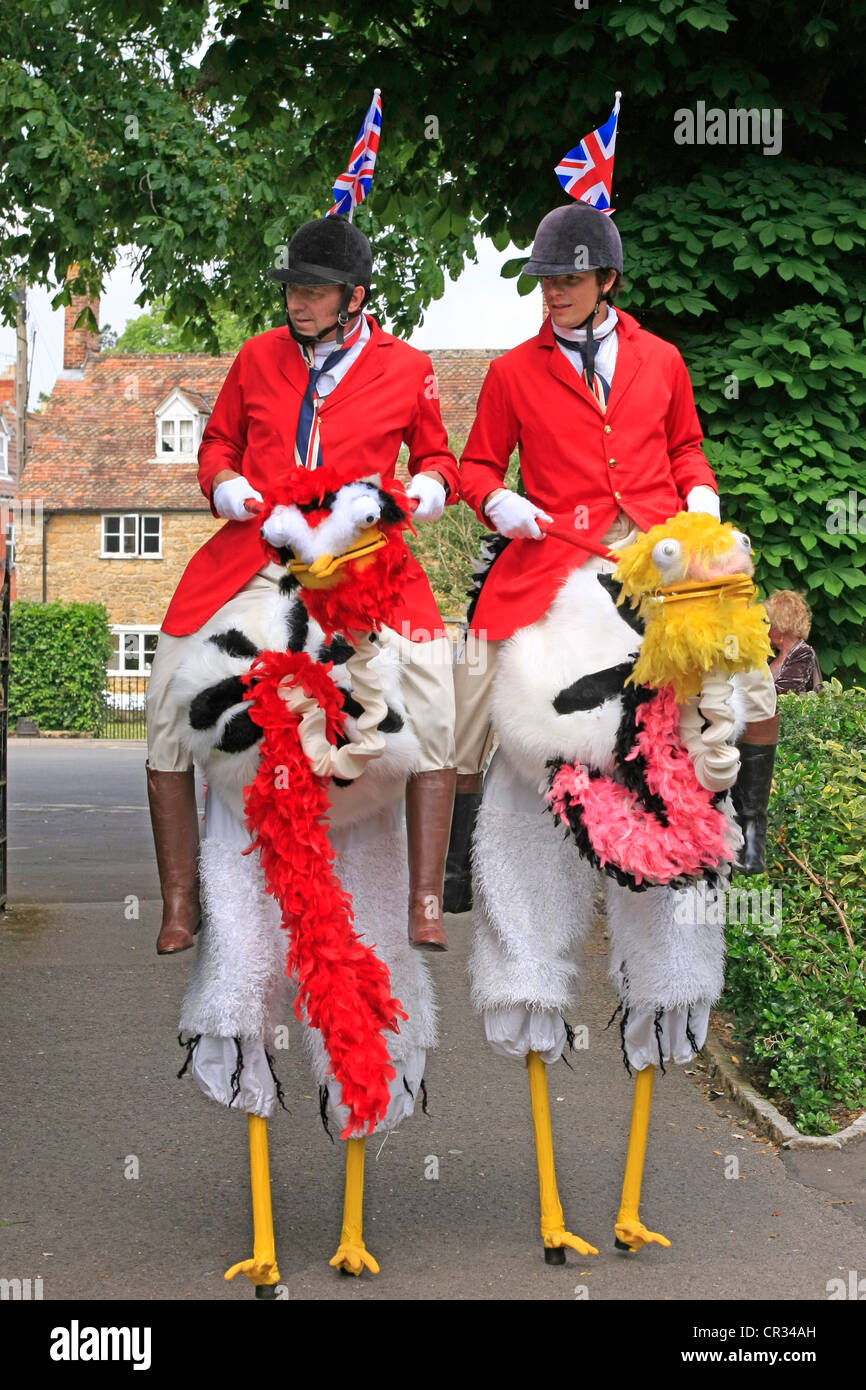 Stelzen laufen Strauß Reiten Comedians auf einer Park-Party in Dorset Stockfoto