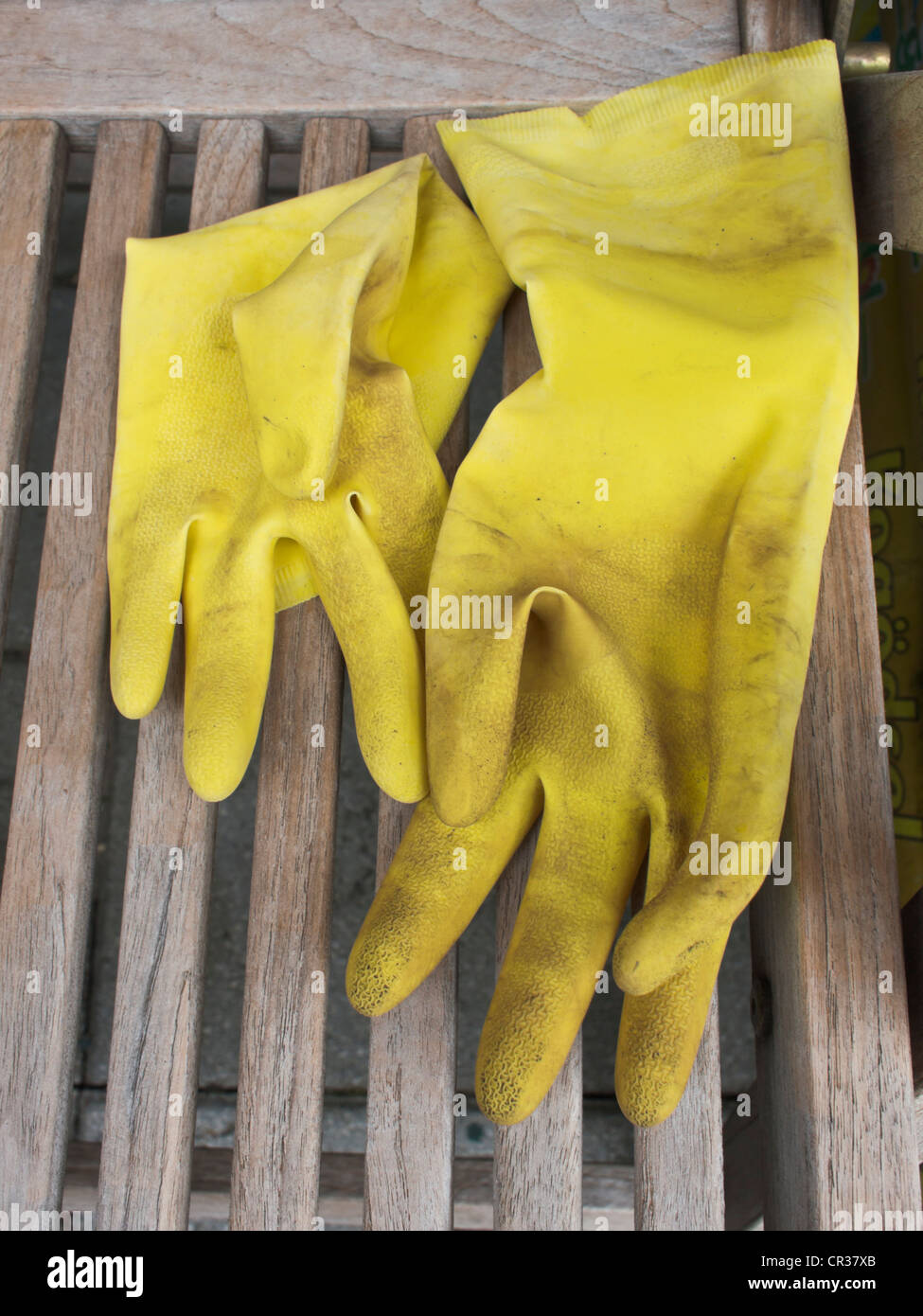 Schmutzig gelb Kunststoff-Handschuhe, die fr die Gartenarbeit Verlegung  auf einem Holzstuhl Garten verwendet wurde Stockfotografie - Alamy