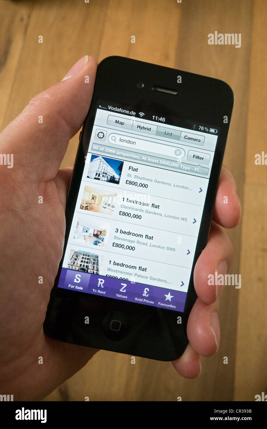Ein iPhone 4G Smartphone verwenden, um ein Haus zu kaufen auf Zoopla Grundstück finden Anwendung finden Stockfoto