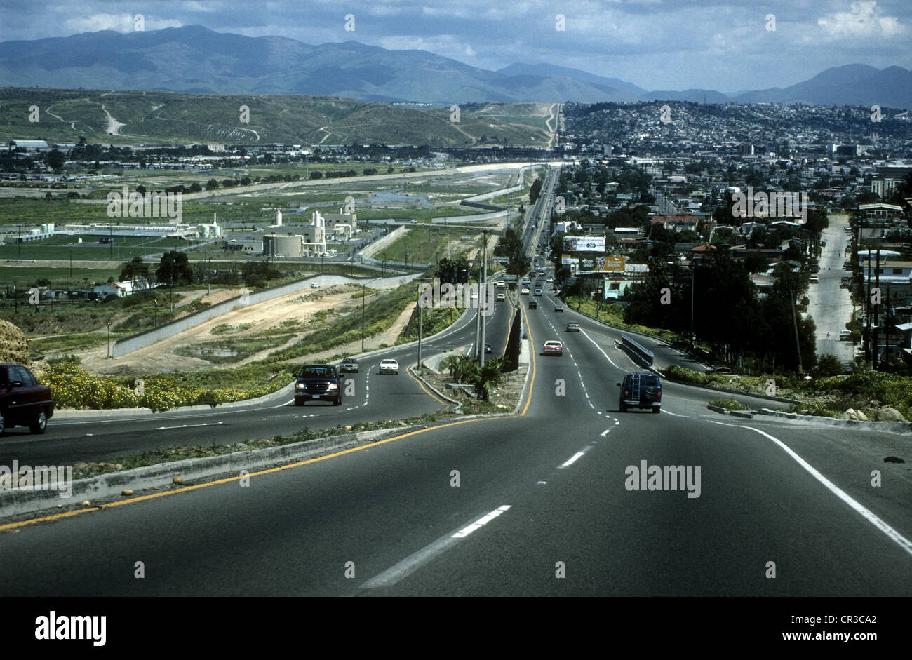 Zweispurige Straße in der Nähe von Tijuana, die parallel zur mexikanischen Grenze mit den USA. Mexiko auf rechten Seite, USA auf linken Seite. Stockfoto