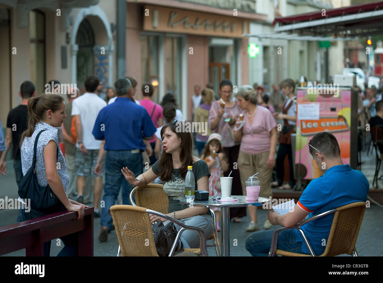 Eine Frau im Gespräch mit einem Freund in einem Straßencafé, Lemberg, Ukraine Stockfoto