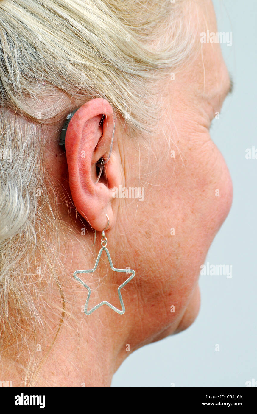Moderne kleine hören hinter dem Ohr einer Frau, 55-60 Jahre, Ohrring, Schwerhörigkeit Hilfe Stockfoto