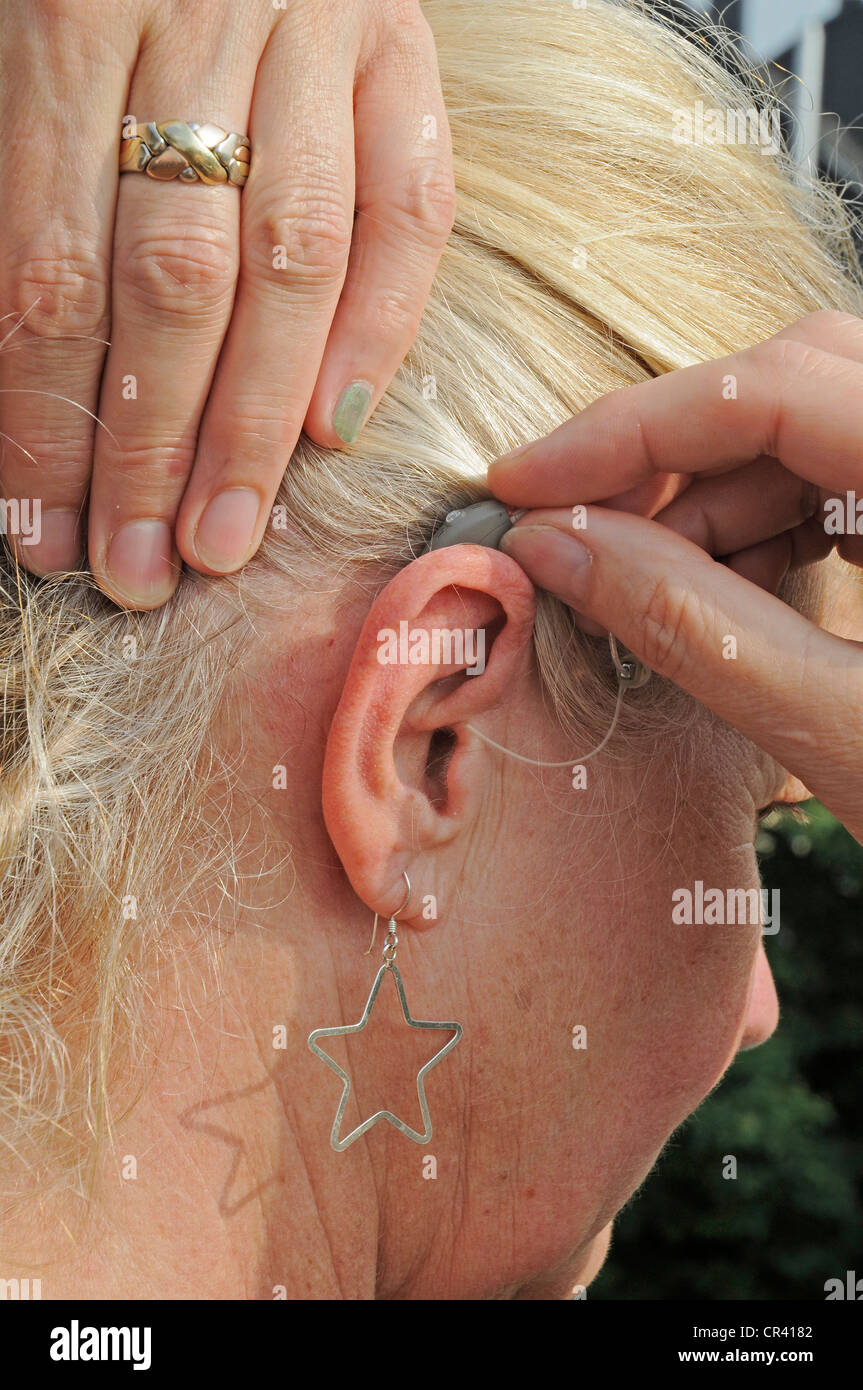 Moderne kleine Hörgerät hinter dem Ohr eine Frau, 55-60 Jahre, Schwerhörigkeit Stockfoto