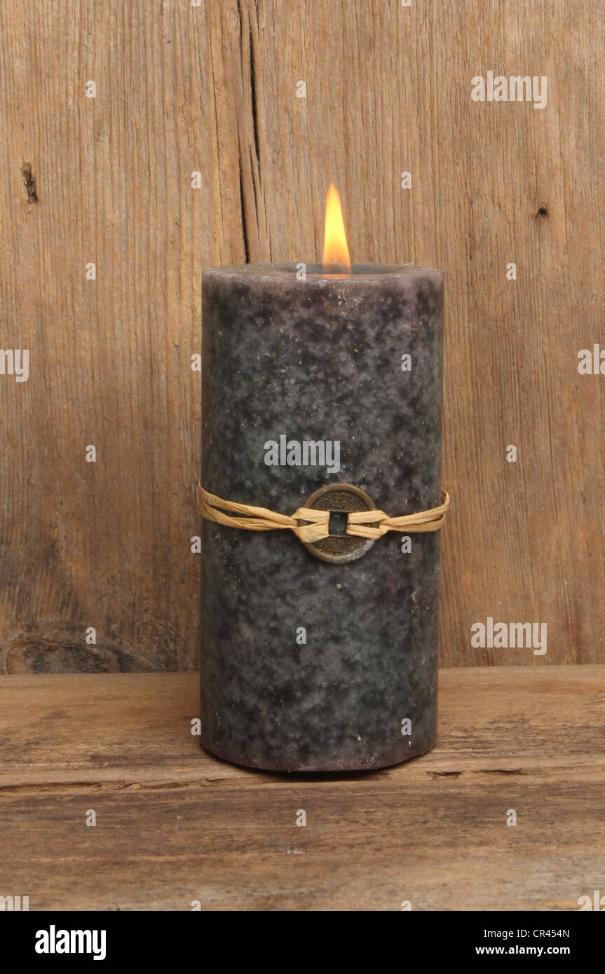 Feng Shui Kerze verbrennen auf einem Hintergrund von rustikalen Holz Stockfoto