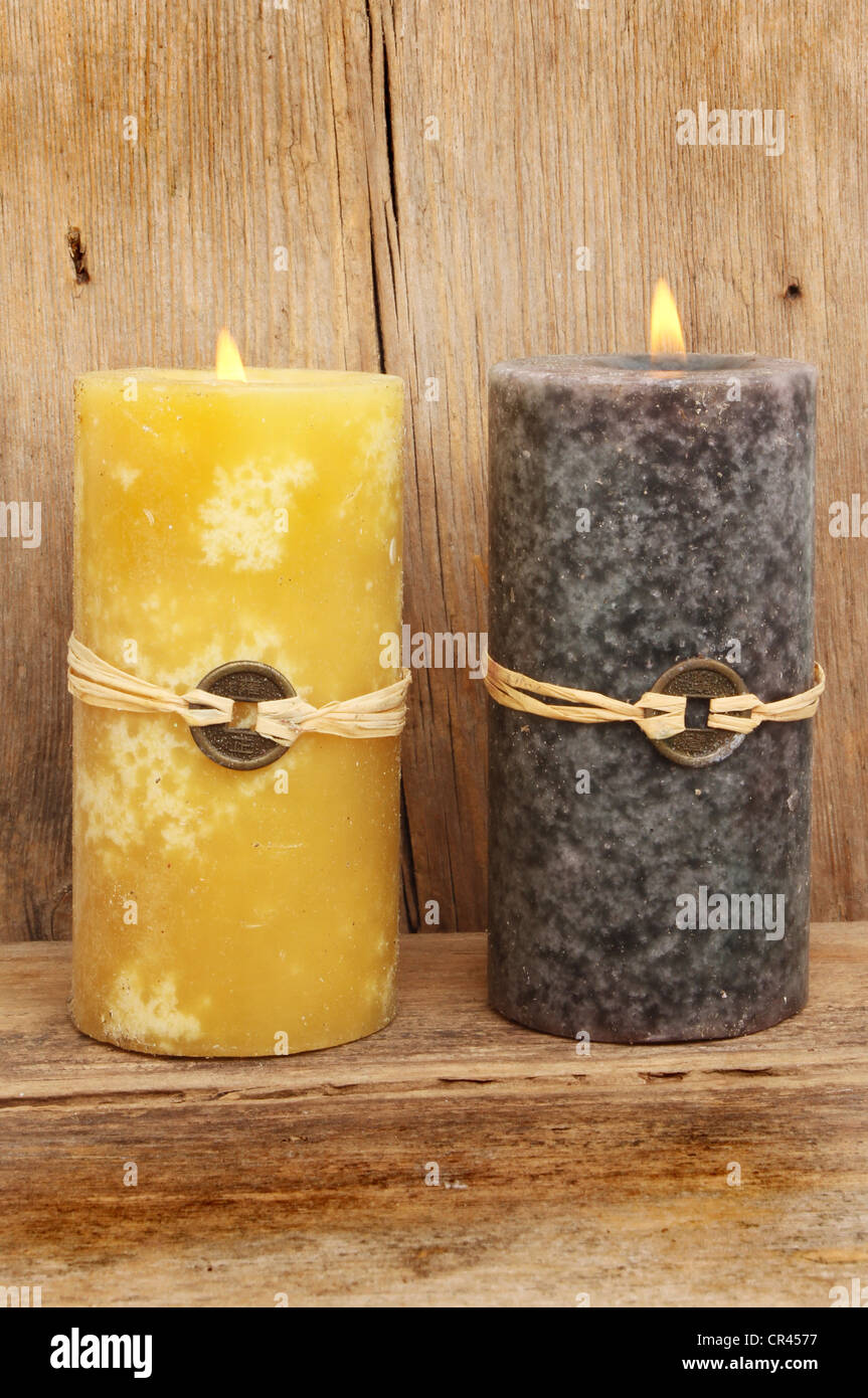 Zwei brennende, die Feng Shui Kerzen vor dem Hintergrund der alten verwitterten Holz Stockfoto