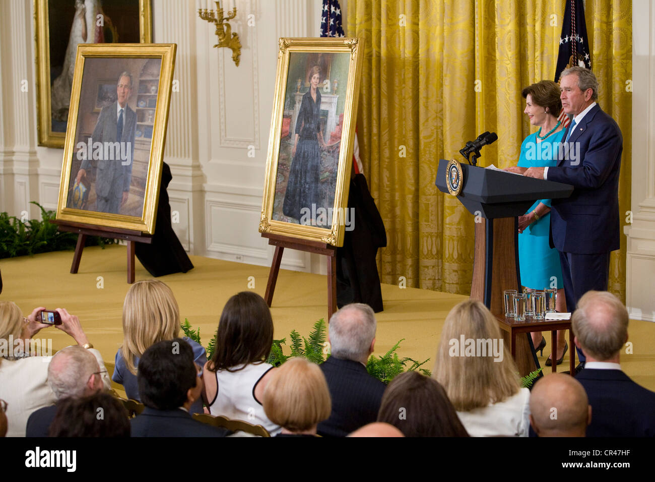 Ehemaligen Präsidenten George W. Bush eine First Lady Laura Bush im Weißen Haus Zeremonie, seine offizielle Porträt zu enthüllen. Stockfoto