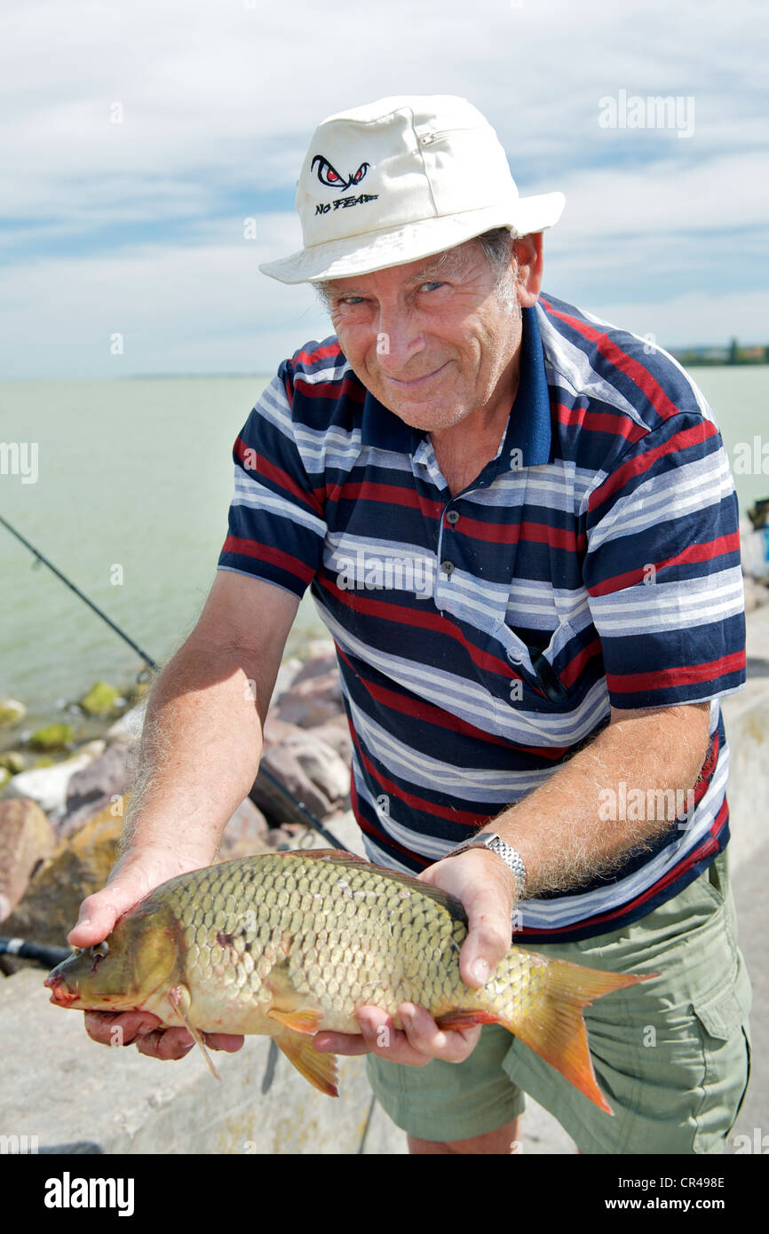 Fischer mit seinem Fang auf der Mole von Balatonszemes Marina am südlichen Ufer des Plattensees in Ungarn. Stockfoto