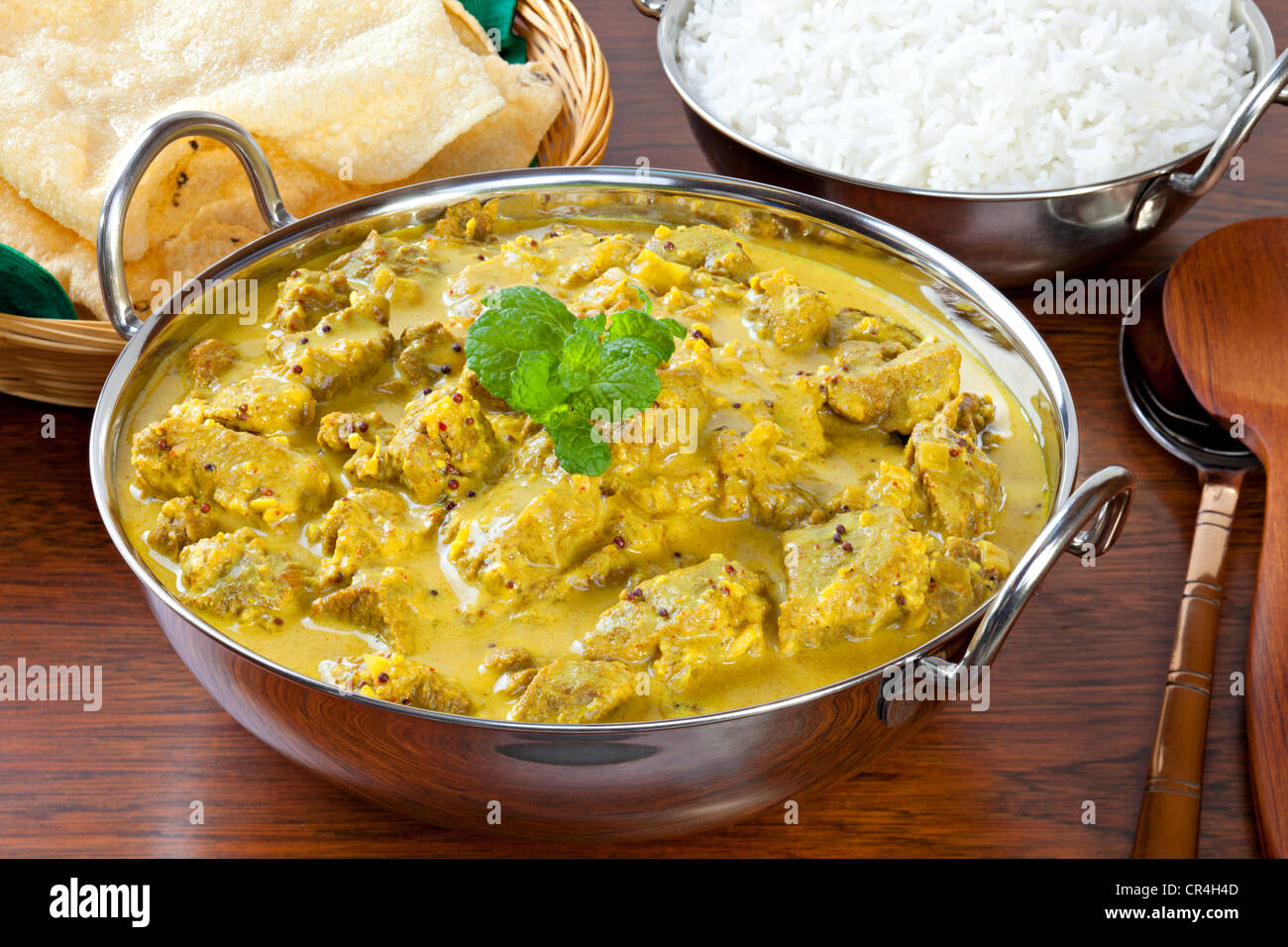 Beef Madras Curry, mit viel Chili, Kokosnuss und Senf Samen, serviert mit Poppadums und Basmati Reis gemacht. Stockfoto