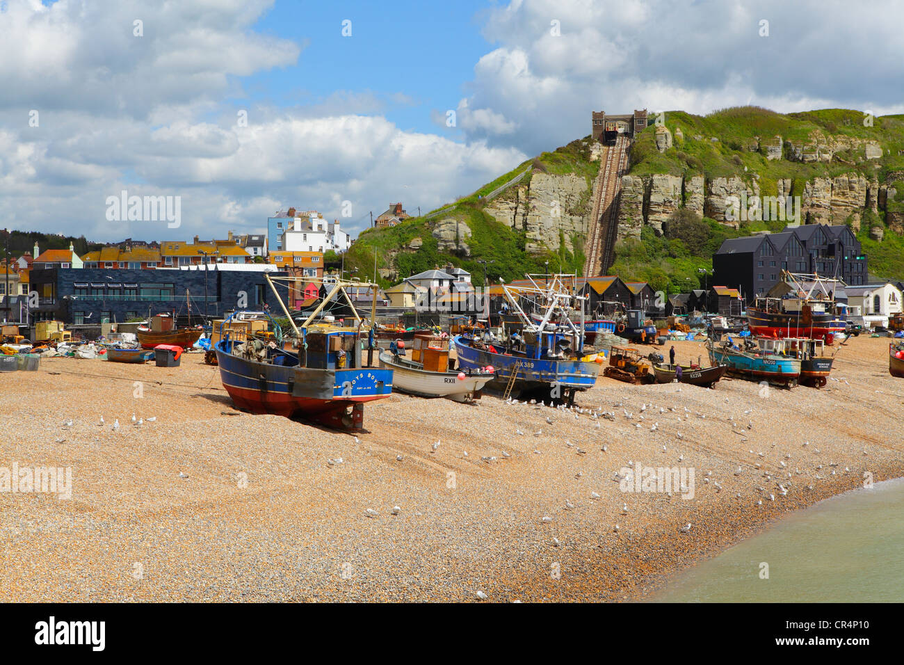 Fischerboote auf Hastings Old Town Stade Beach vor der schwarz gefliesten Hastings Contemporary Art Gallery, East Sussex, UK, GB Stockfoto