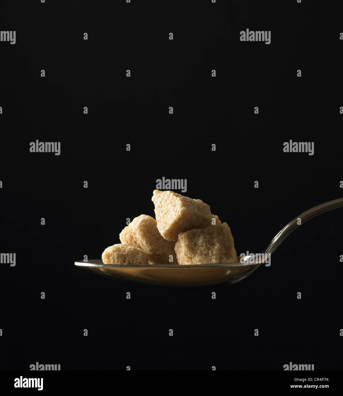 Esslöffel brauner Zucker auf schwarzem Hintergrund Stockfoto