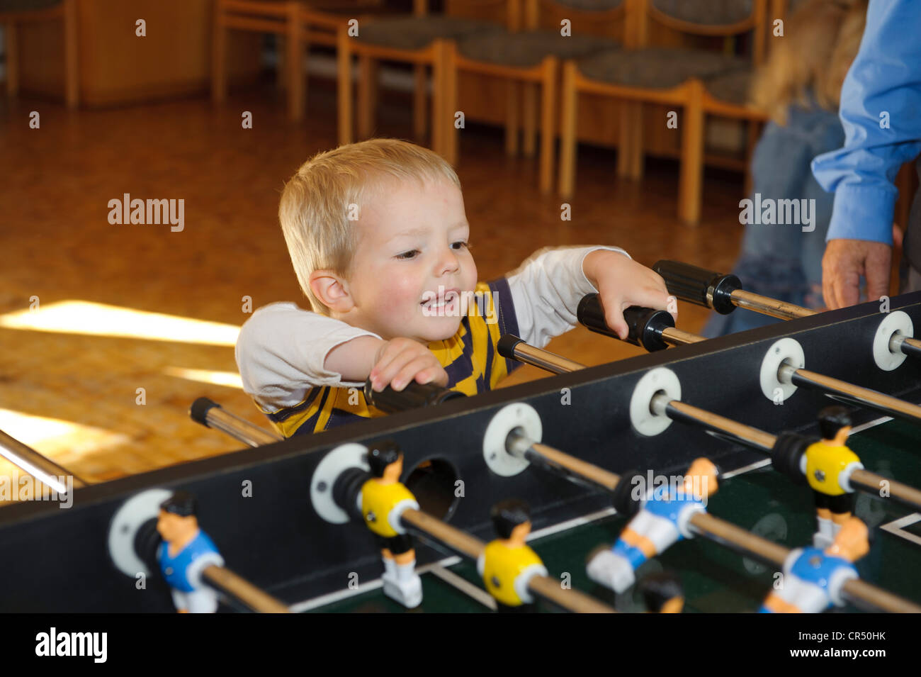 Junge, 2 Jahre, zu klein, Tischfußball spielen Stockfoto