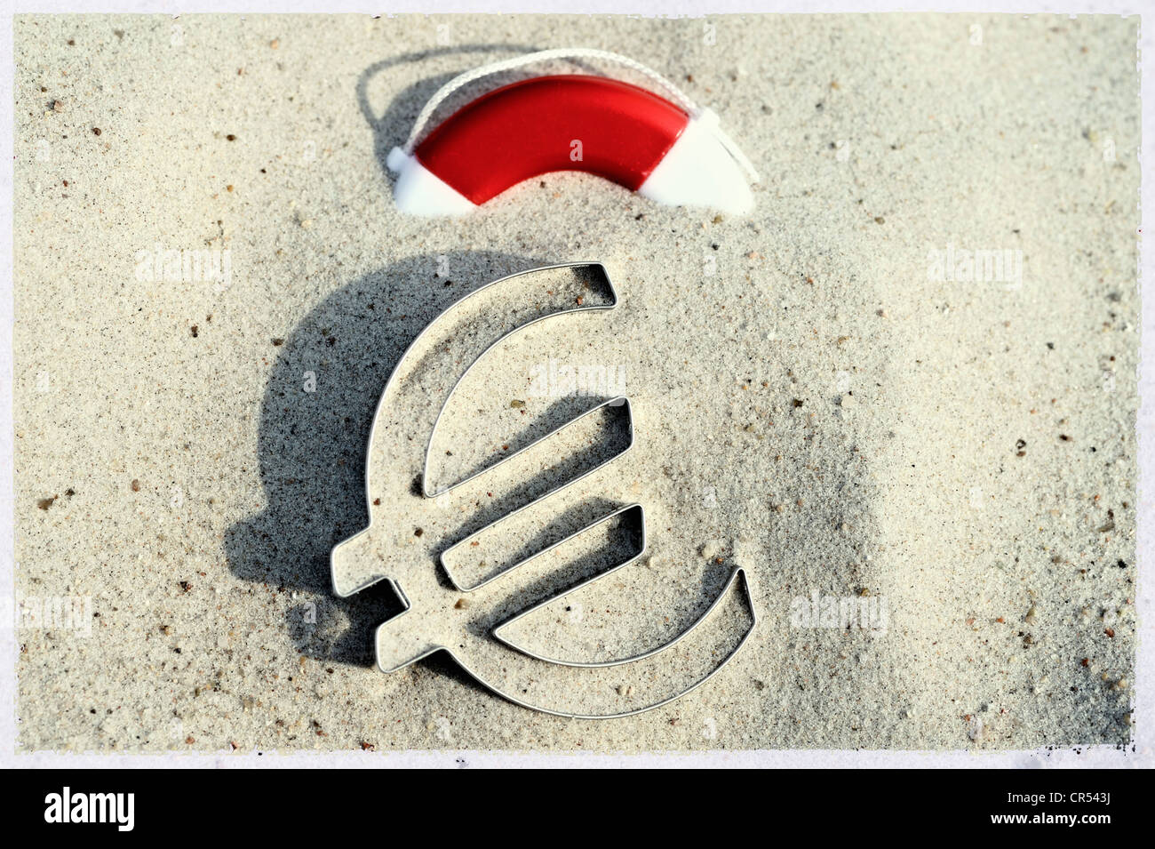 Euro-Symbol liegen auf einem Strand neben einem Rettungsring, symbolisches Bild für die Euro-Krise Stockfoto