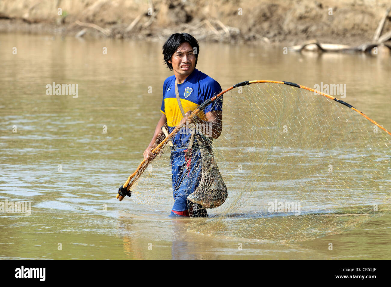 Junger Mann aus dem indigenen Wichi-Indianer-Stamm mit einem traditionellen Netz im Fluss Pilcomayo Angeln Stockfoto