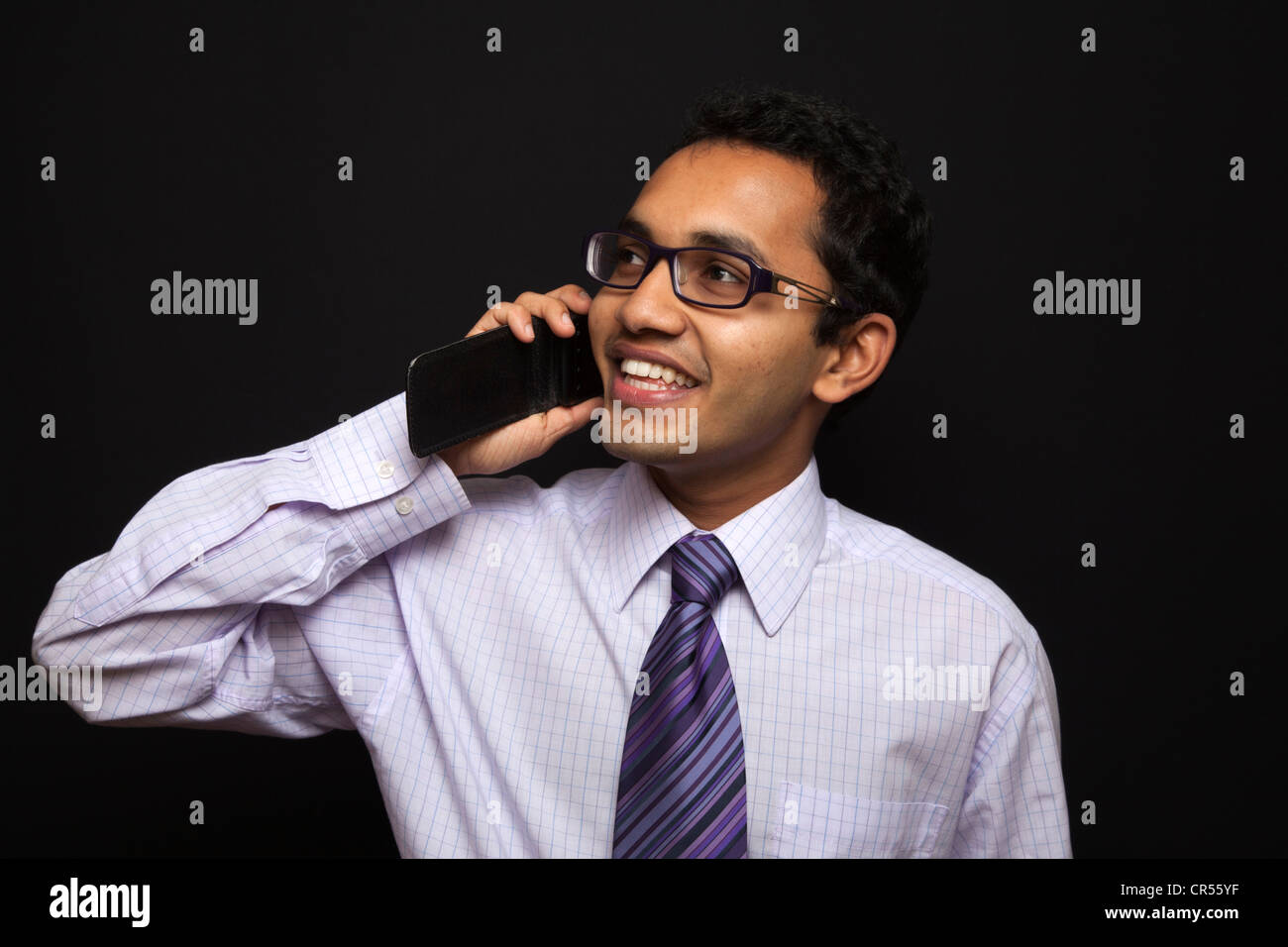 Ein glücklicher Geschäftsmann, der über ein Mobiltelefon spricht. Stockfoto