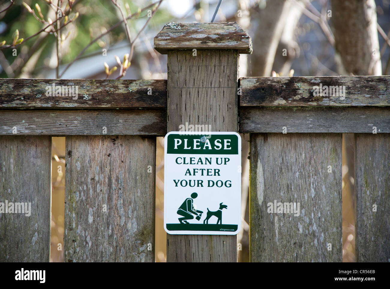 Melden Sie auf einem Zaunpfahl Leute Fragen zu bereinigen, nachdem ihr Hund Stockfoto
