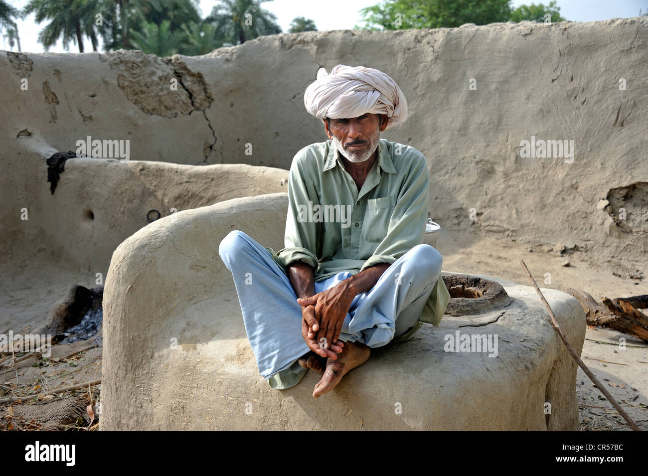 Älterer Mann mit Turban sitzt auf einem Brotbackofen, Basti Lehar Walla Dorf, Pubjab, Pakistan, Asien Stockfoto