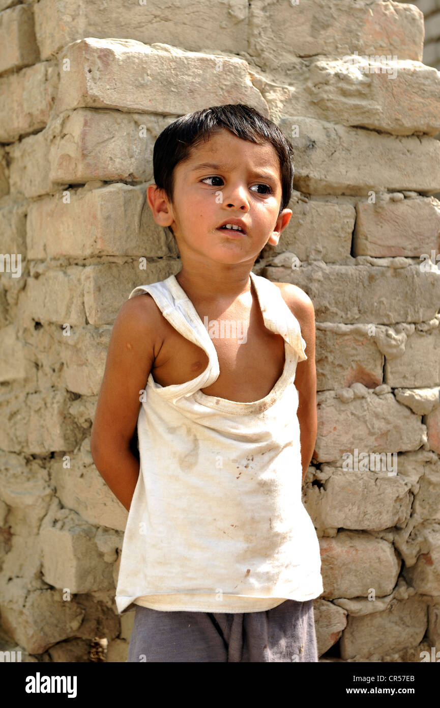 Junge, 3, tragen eine zerrissene Unterhemd, die zu groß ist, lehnt sich gegen eine Wand, Dorf von Moza Sabgogat in der Nähe von erschöpft Stockfoto