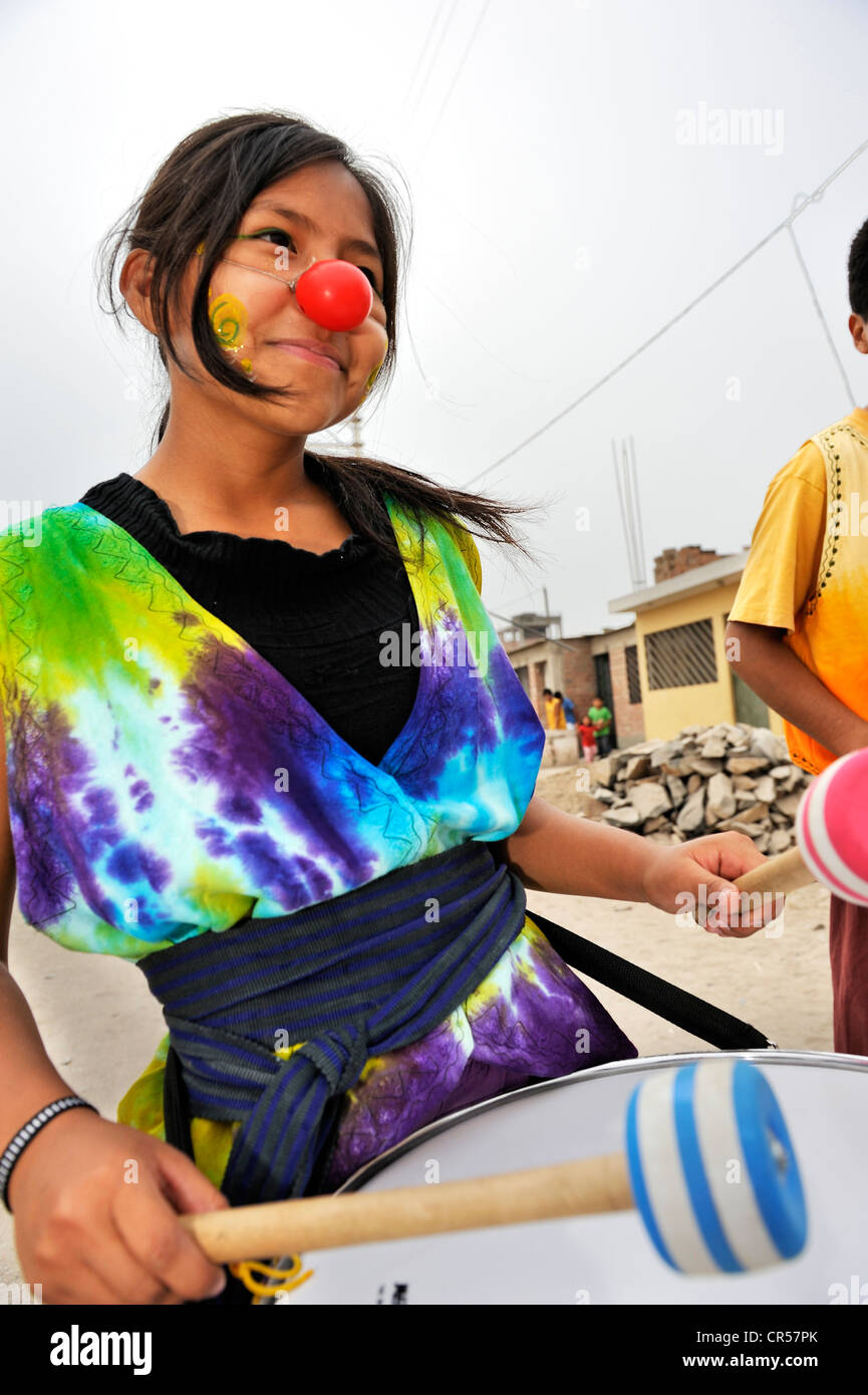 Mädchen mit einer Trommel trägt eine Clownsnase, Arena y Esteras Projekt, Jugendliche durch die Straßen marschieren verkleidete sich als Straße Stockfoto