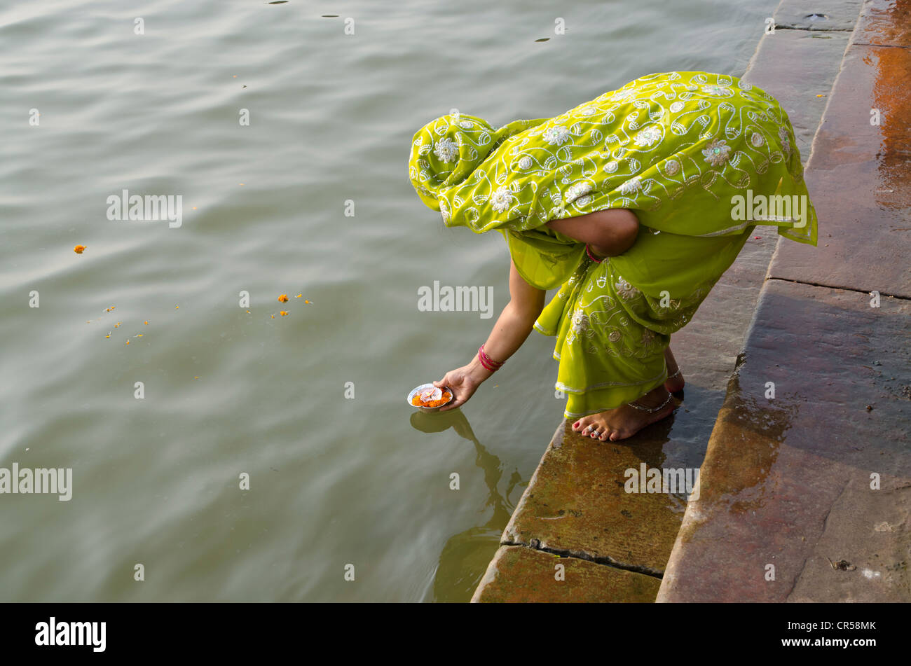 Frau geben Angebote auf dem heiligen Fluss Ganges als Bestandteil ihrer Pilgerreise, Varanasi, Uttar Pradesh, Indien, Asien Stockfoto