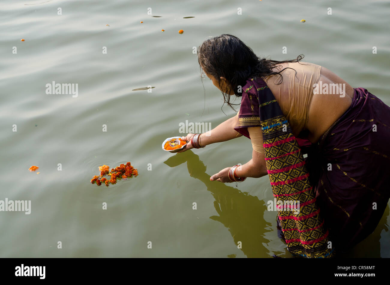 Frau geben Angebote auf dem heiligen Fluss Ganges als Bestandteil ihrer Pilgerreise, Varanasi, Uttar Pradesh, Indien, Asien Stockfoto