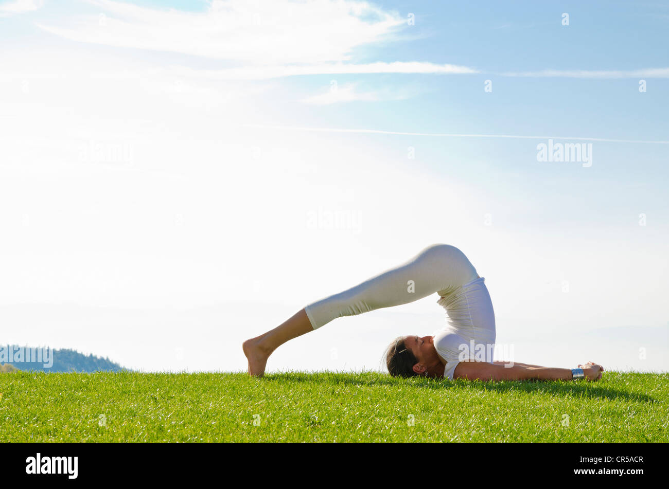 Junge Frau praktizieren Hatha Yoga im Freien, zeigen die Pose Halasana, Pflug, Nove Mesto, Okres Teplice, Tschechische Republik, Europa Stockfoto