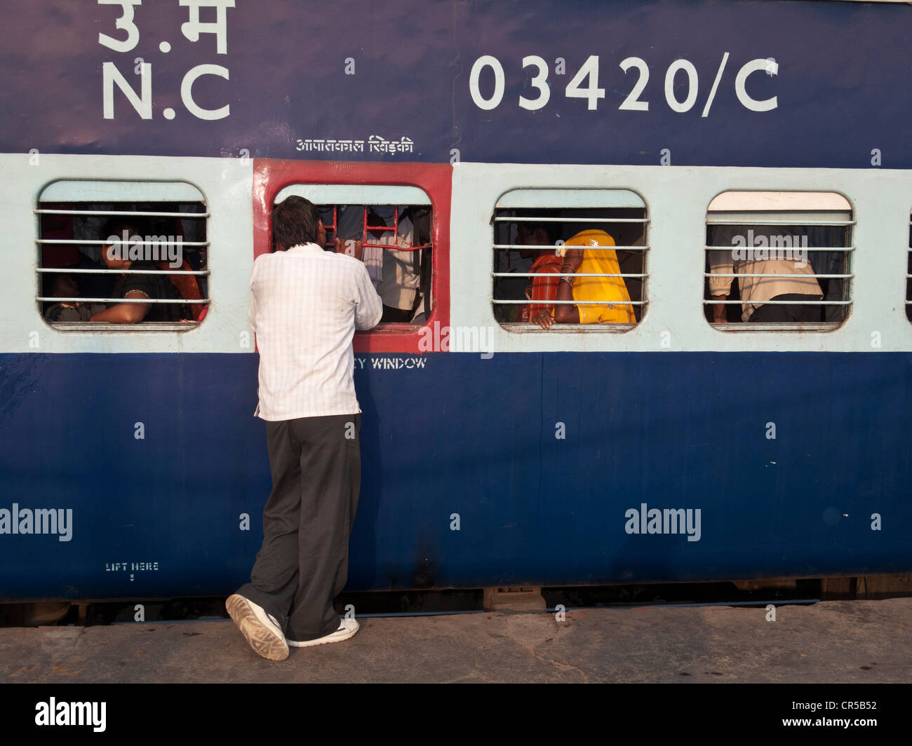 Mann im Gespräch mit Personenzug vor des Zuges aus New Delhi Railway Station, New Delhi, Indien, Asien Abfahrt Stockfoto