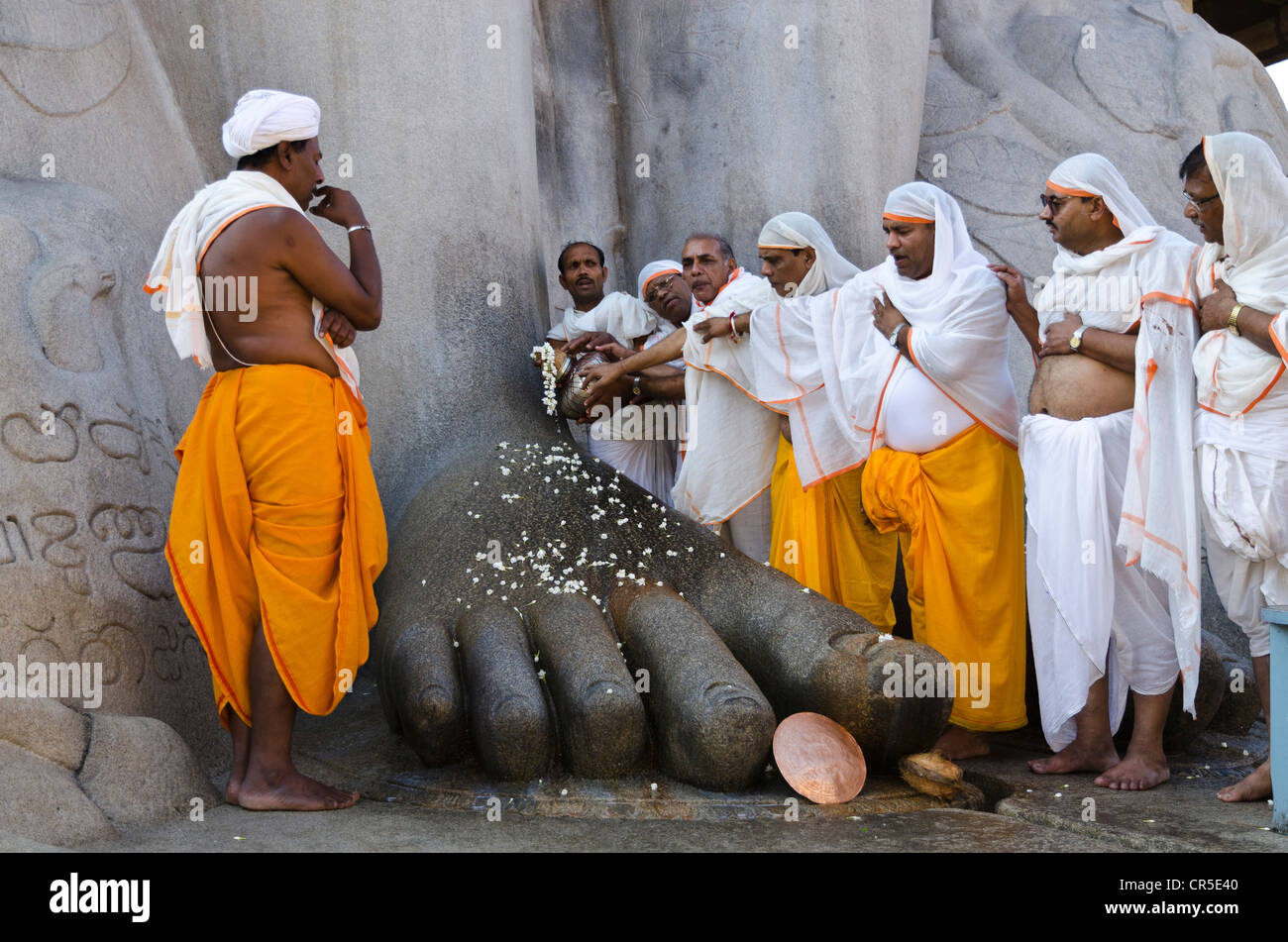 Eine Gruppe von Jain Pilgern tun eine spezielle Pooja vor der riesigen Statue die Segnungen von Bahubali von den örtlichen Stockfoto