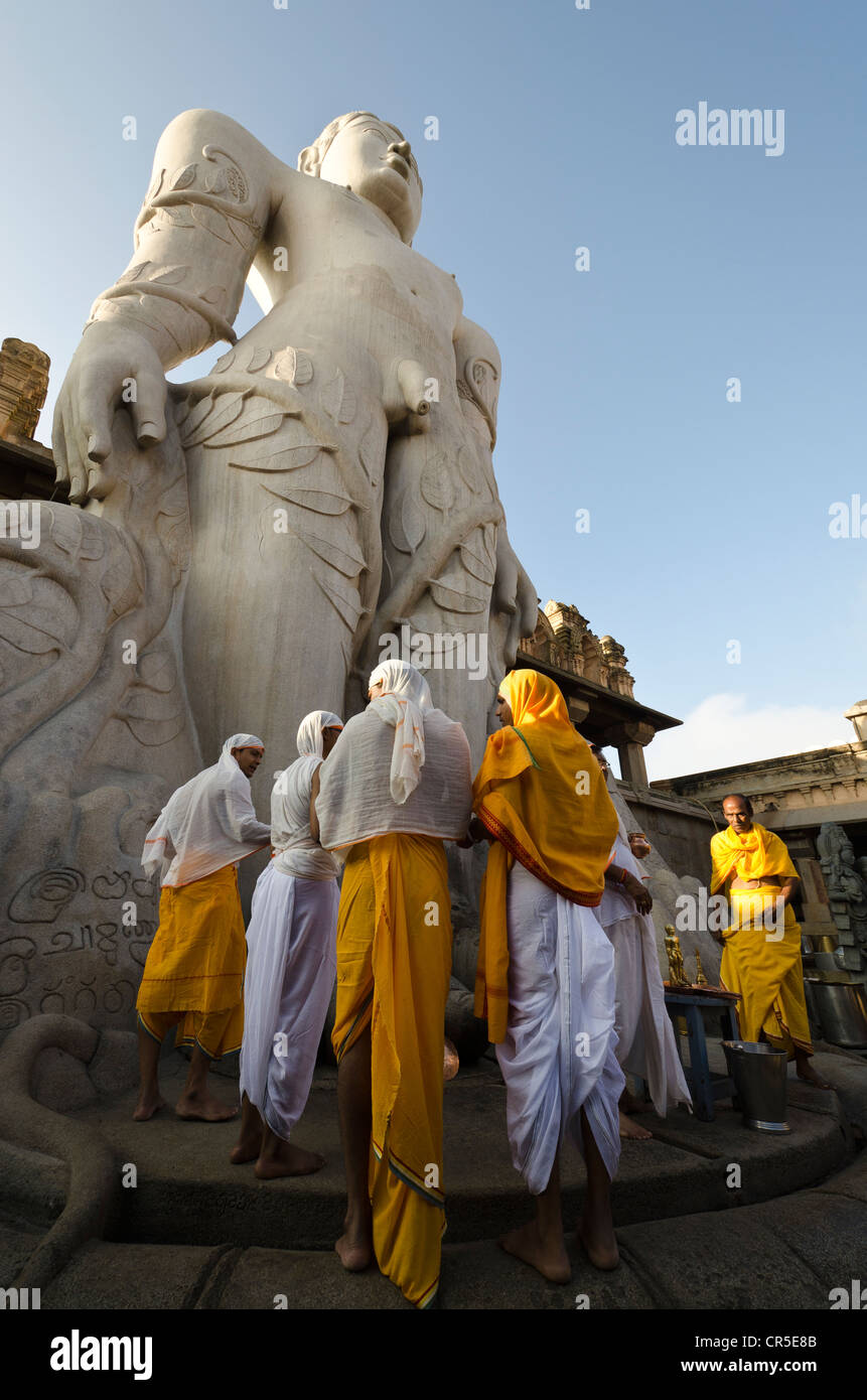 Eine Gruppe von Jain Pilgern tun eine spezielle Pooja die Segnungen von Bahubali von den lokalen Priestern vor der statue Stockfoto