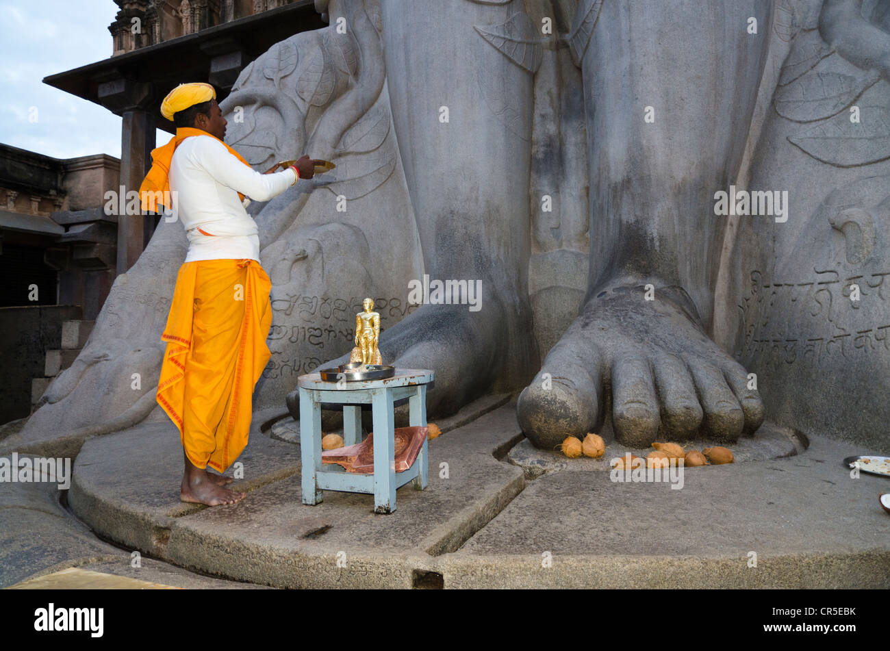 Ortspfarrer seine Gebete vor der Statue von Lord Gomateshwara, der höchste monolithische Statue in der Welt zu tun, Stockfoto