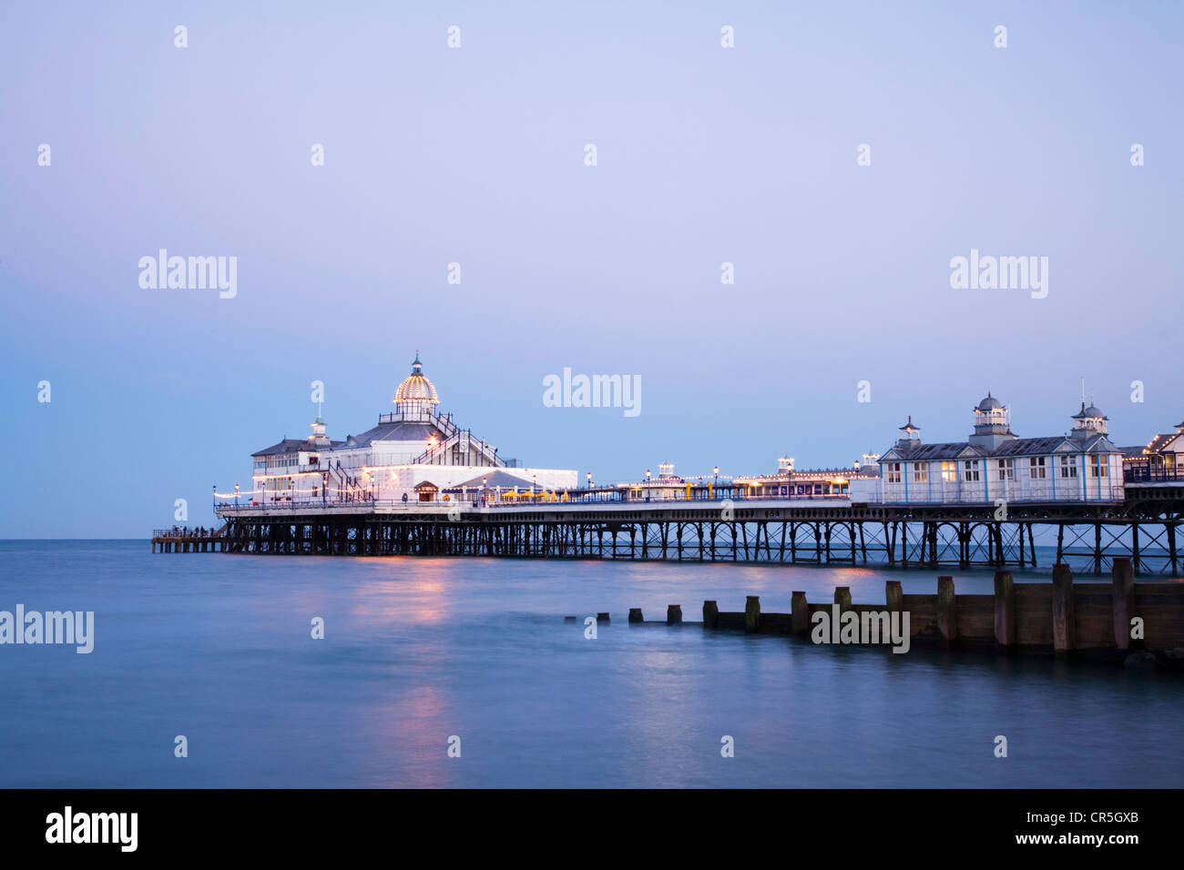 Die Pier in Eastbourne, Sussex, in der Dämmerung an einem Sommerabend klar beleuchtet. Stockfoto