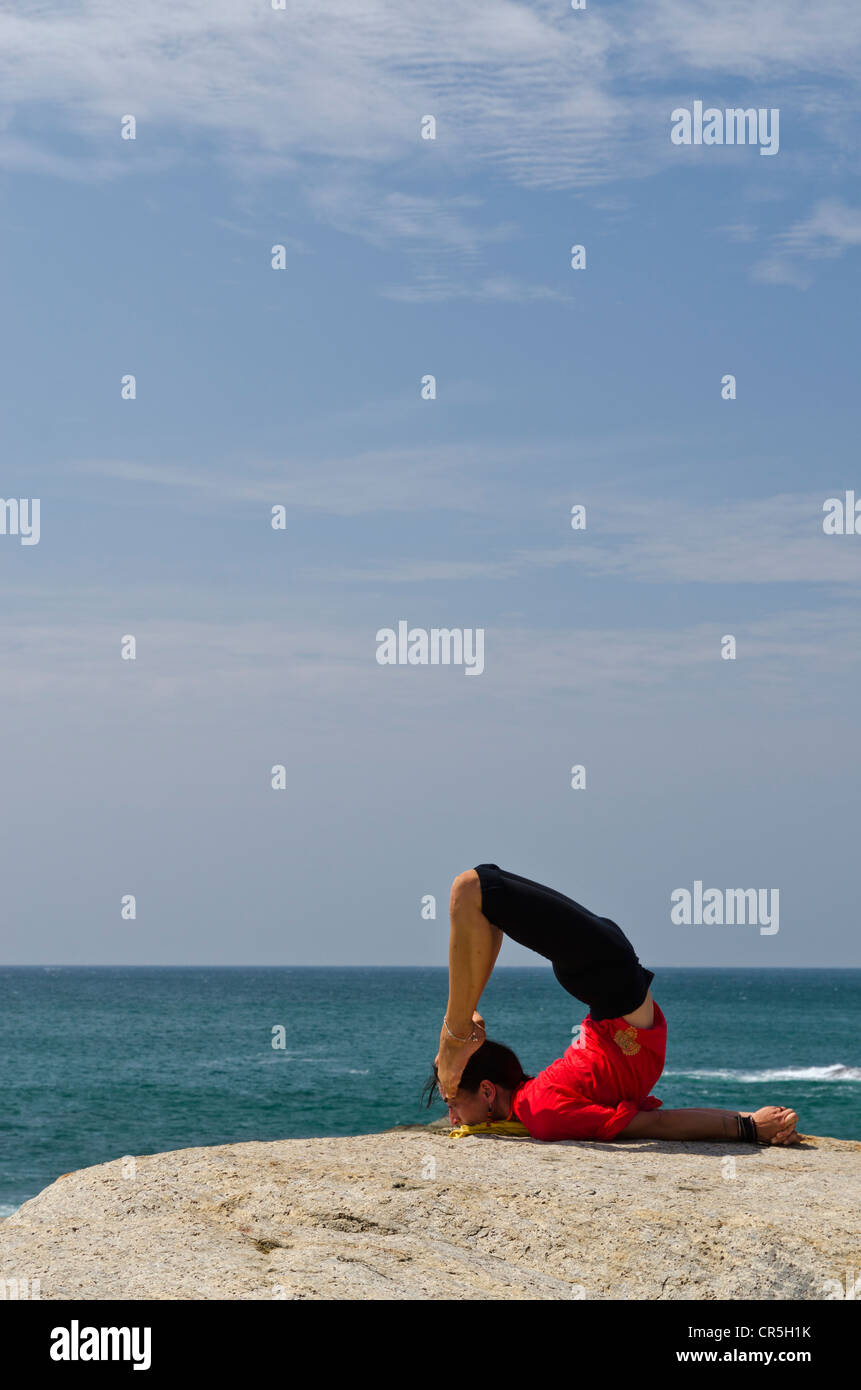 Frau in einem Yoga-position, Salabhasana, direkt am Meer in Kanyakumari, Tamil Nadu, Indien, Asien Stockfoto