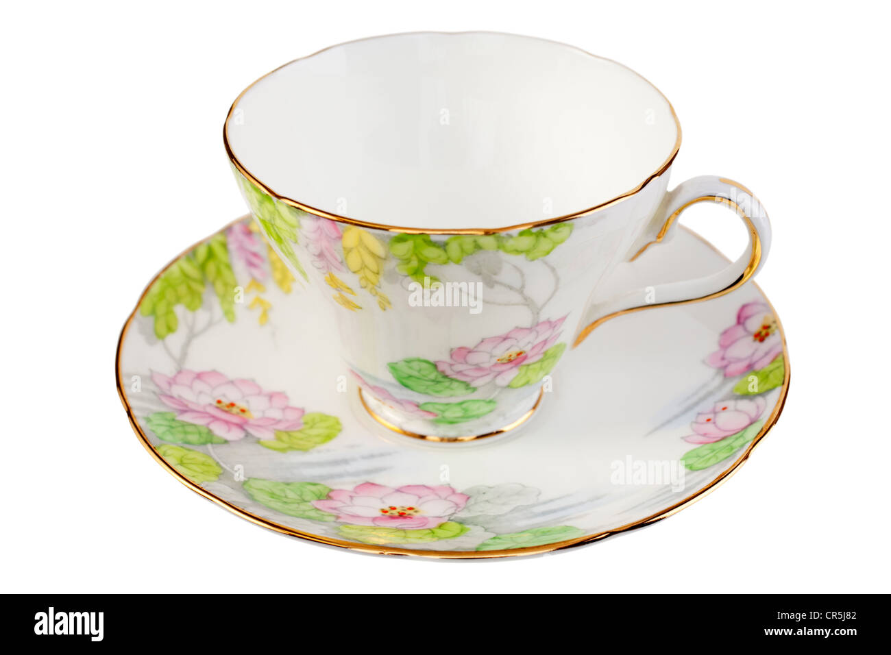 Alte Porzellan Tasse und Untertasse mit einem ziemlich Blumendesign in Pastellfarben, isoliert auf weiss. Stockfoto