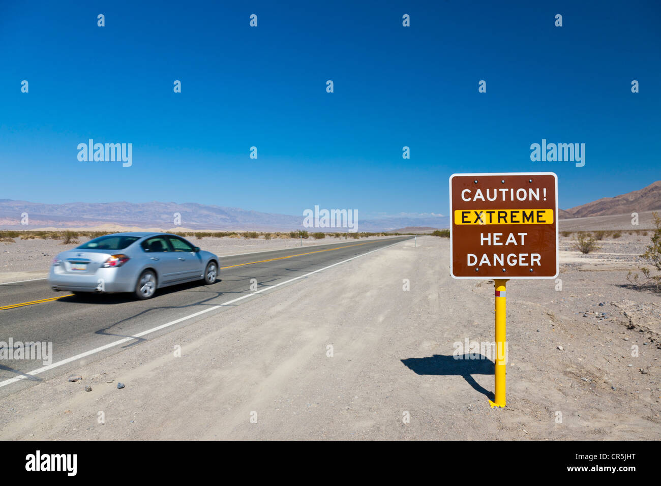 "Vorsicht Extreme Hitze Gefahr" Schild mit Auto vorbei, Route 190, Death Valley, Kalifornien, USA. JMH5345 Stockfoto