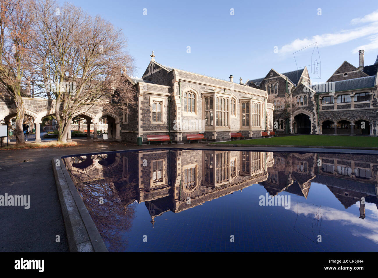 Gebäude rund um den Norden Quad in Christchurch Arts Centre (die alte Canterbury University), reflektiert in einem Pool im Winter. Stockfoto