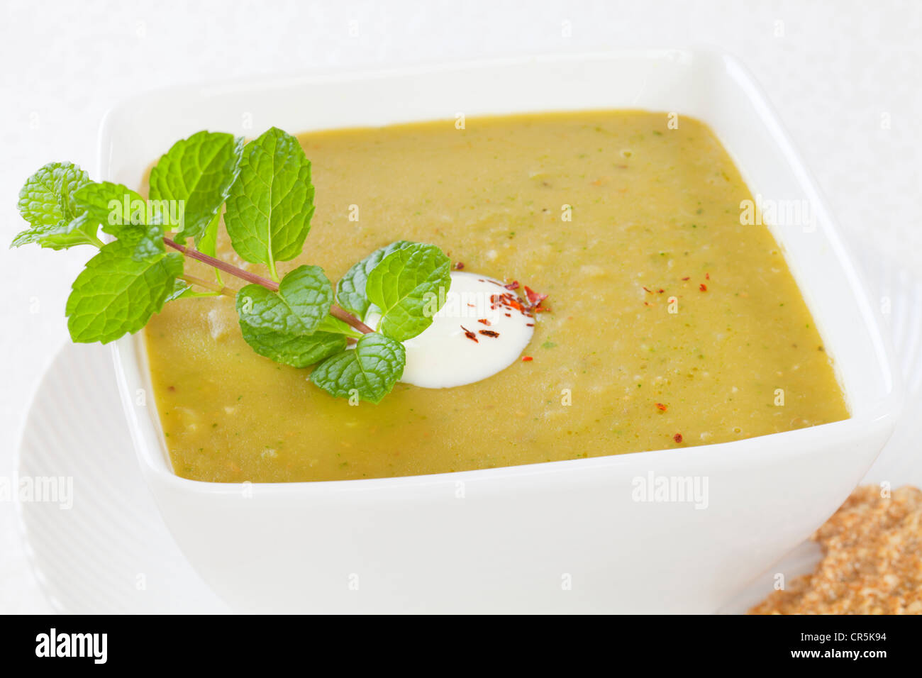 Heimelige Erbsensuppe mit einem Klecks Joghurt und Minze. Stockfoto