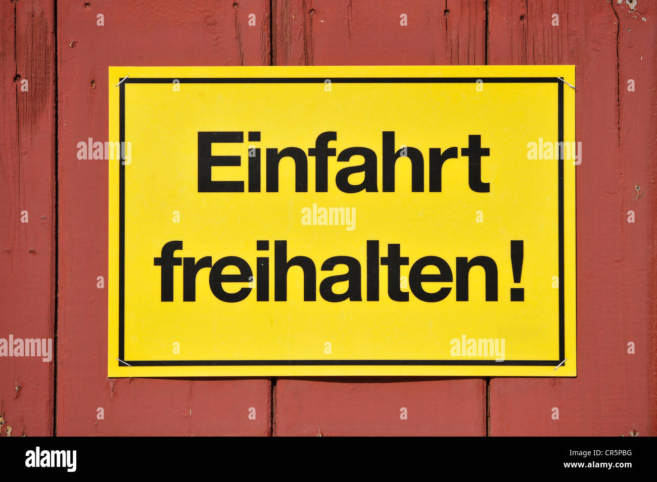 Zeichen, Bibliotheksgebäudes Freihalten! Deutsch für Keep Eingang klar, gelb auf einem roten Holztor, Deutschland, Europa Stockfoto