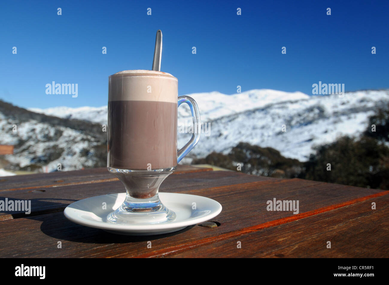 Heiße Schokolade trinken am Tisch im Restaurant im Freien, Guthega, Kosciuszko-Nationalpark, New South Wales, Australien. Keine PR Stockfoto