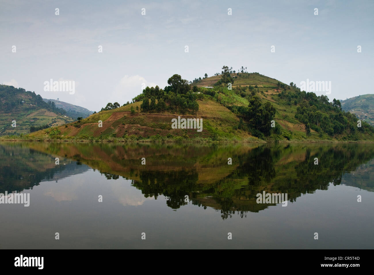 Hill spiegelt sich in glatte Oberfläche des Lake Bunyonyi, West-Uganda, Afrika Stockfoto