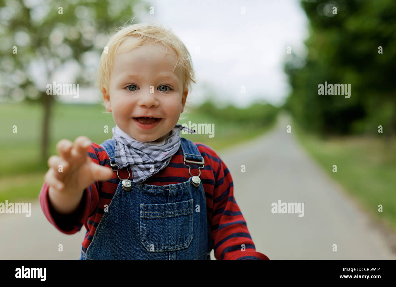 Junge (17 Monate alt) zu erreichen, in Richtung der Kamera auf einem Feld lane Stockfoto